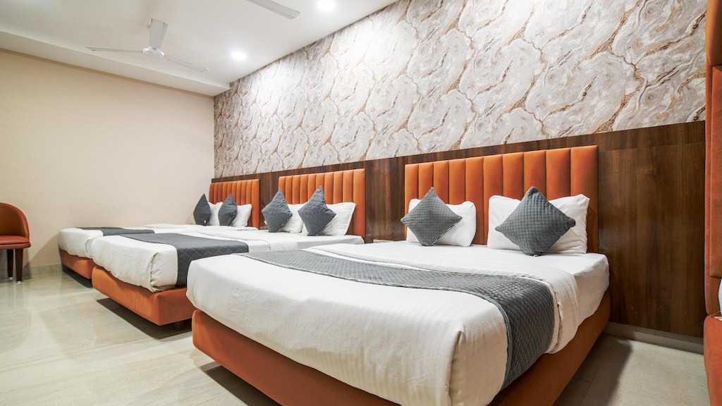 AC basic room at Vasavi Bhavan with two large double beds, modern décor, and comfortable bedding for pilgrims and travelers.

